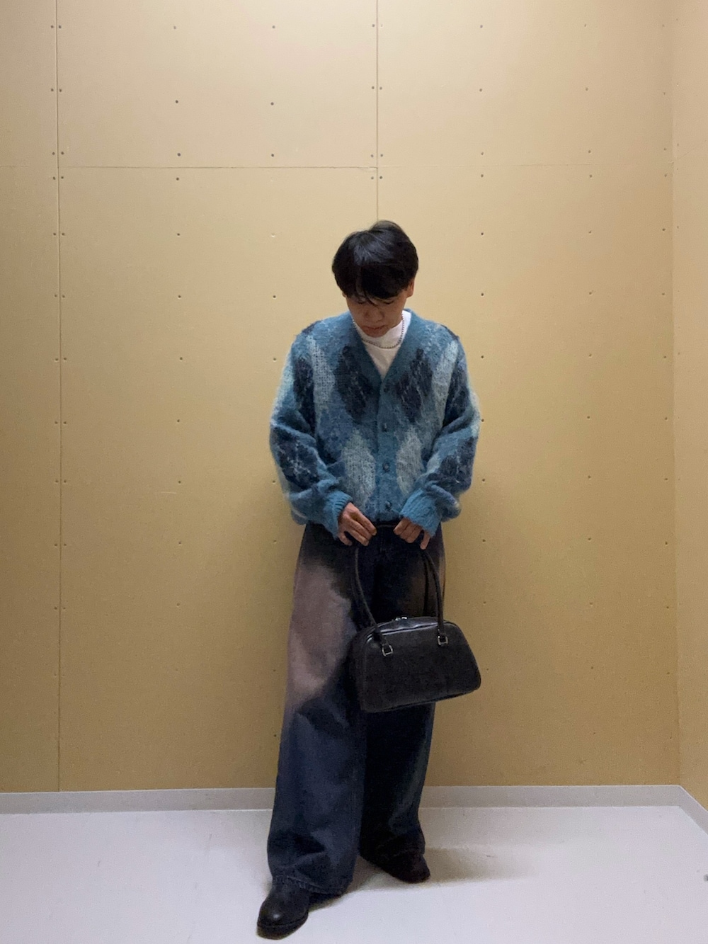 ブルー系のニット/セーター、ブルー系のデニムパンツ、ホワイト系のTシャツ/カットソーを着用したメンズの秋コーディネートの2枚目の写真