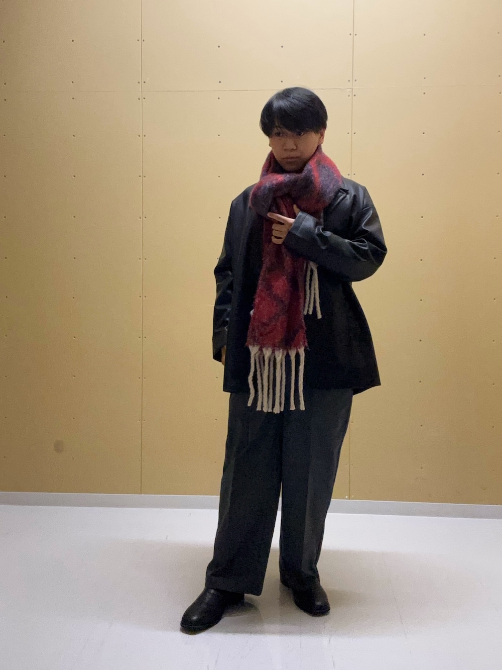 ブラック系のその他アウター、グレー系のニット/セーター、グレー系のスラックスを着用したメンズの秋コーディネートの2枚目の写真