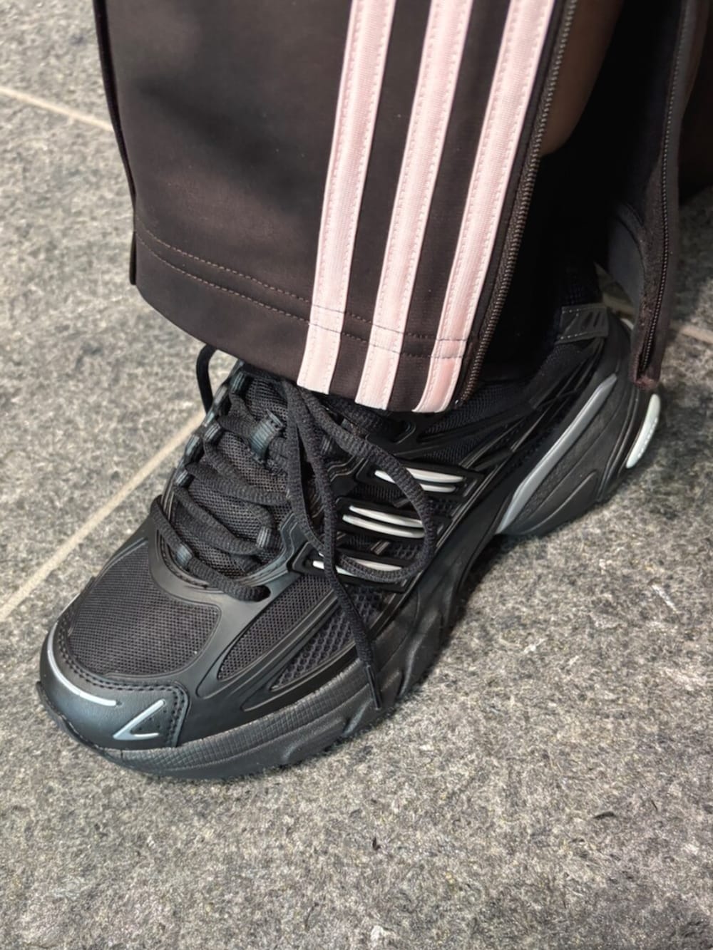 ブラック系のスニーカー、ホワイト系のトップス、ブラウン系のパンツを着用したレディースの冬コーディネートの2枚目の写真