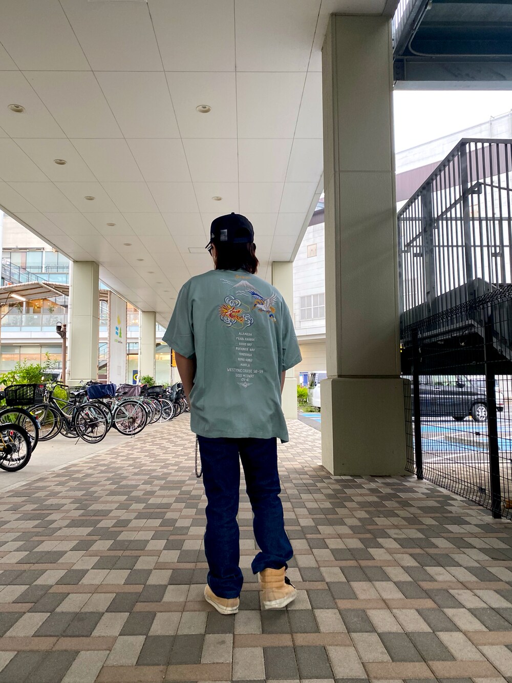 グリーン系のシャツ/ブラウス、ゴールド系のTシャツ/カットソー、ホワイト系のキャップを着用したメンズの春コーディネートの2枚目の写真