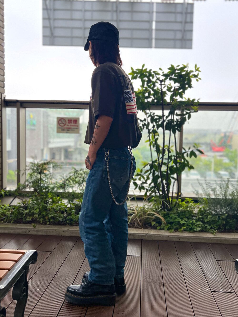 グリーン系のポロシャツ、ブラック系のキャップを着用したメンズの春コーディネートの2枚目の写真