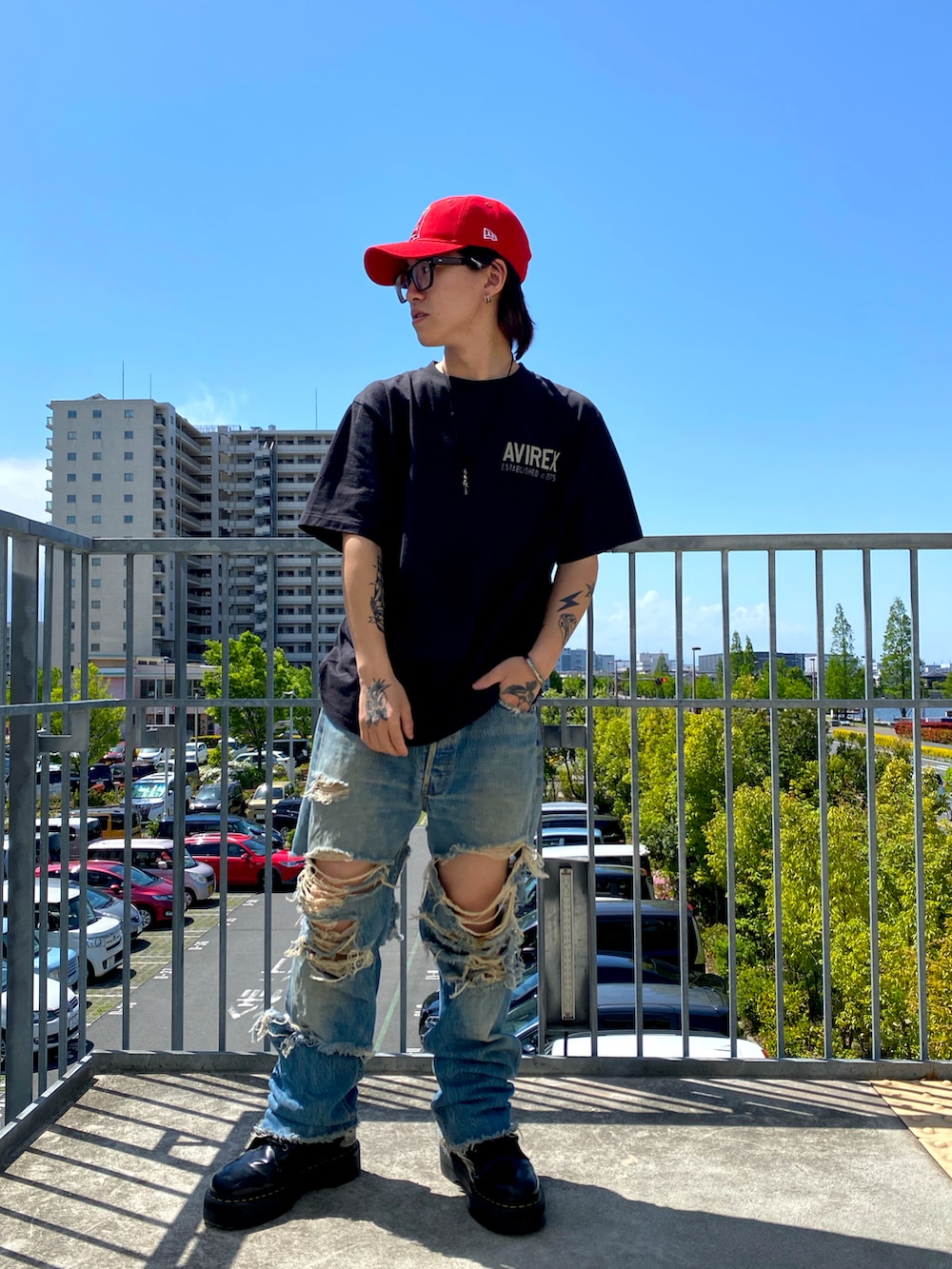 ブラック系のTシャツ/カットソー、レッド系のキャップを着用したメンズの春コーディネートの2枚目の写真