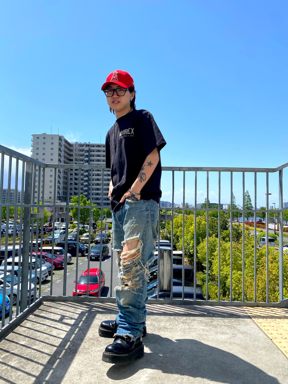 ブラック系のTシャツ/カットソー、レッド系のキャップを着用したメンズの春コーディネートの3枚目の写真