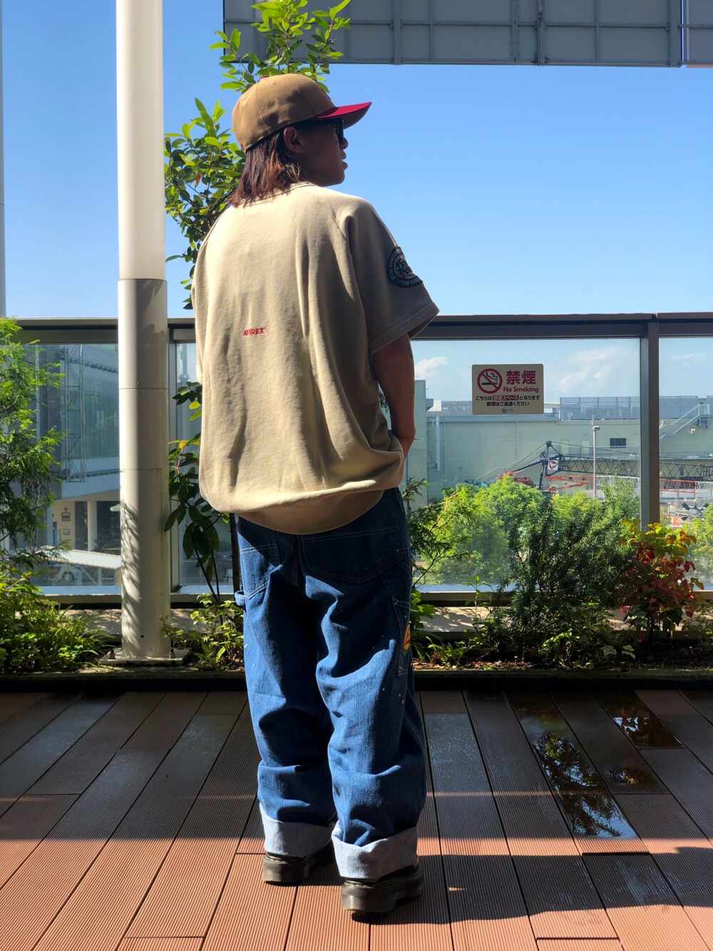 ベージュ系のTシャツ/カットソー、ブルー系のデニムパンツ、ブラウン系のキャップを着用したメンズの夏コーディネートの3枚目の写真