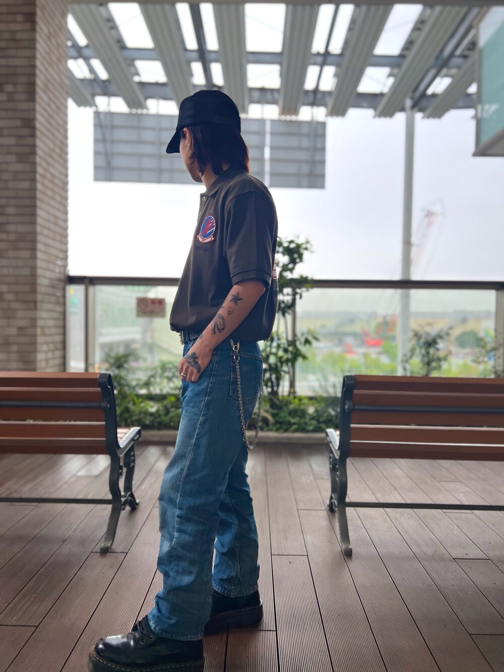 グリーン系のポロシャツ、ブラック系のキャップを着用したメンズの春コーディネートの3枚目の写真