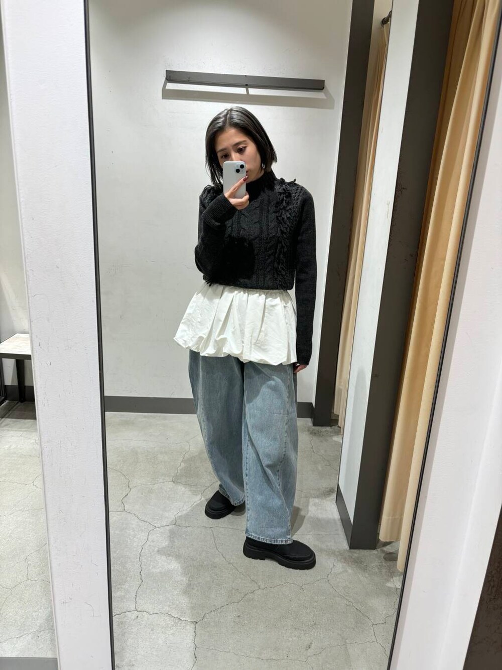 ブルー系のデニムパンツ、ホワイト系のカーディガン/ボレロ、グレー系のニット/セーターを着用したレディースの冬コーディネートの3枚目の写真