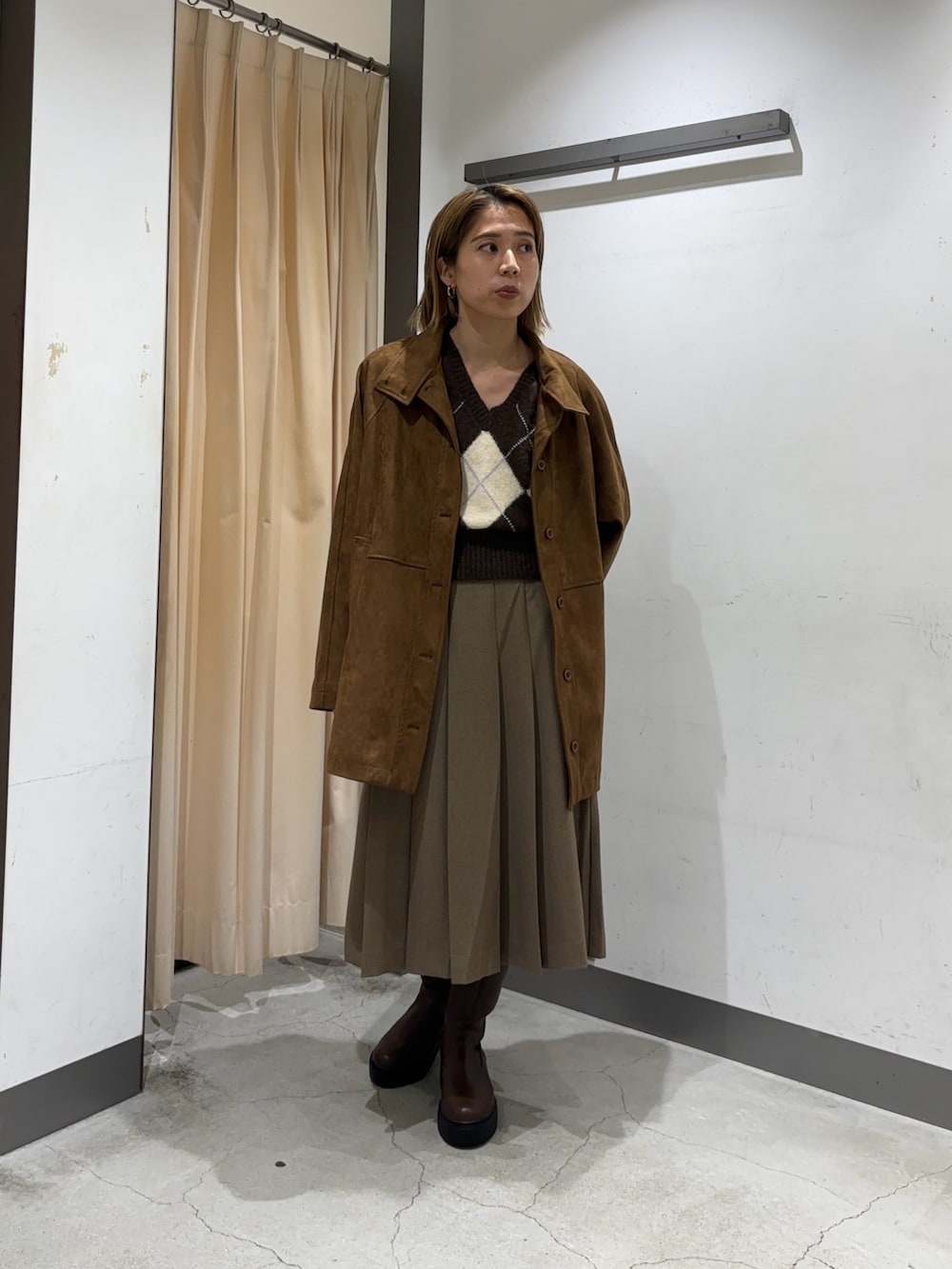 ブラウン系のカバーオール、ブラウン系のベスト、ブラウン系のスカートを着用したレディースの秋コーディネートの3枚目の写真