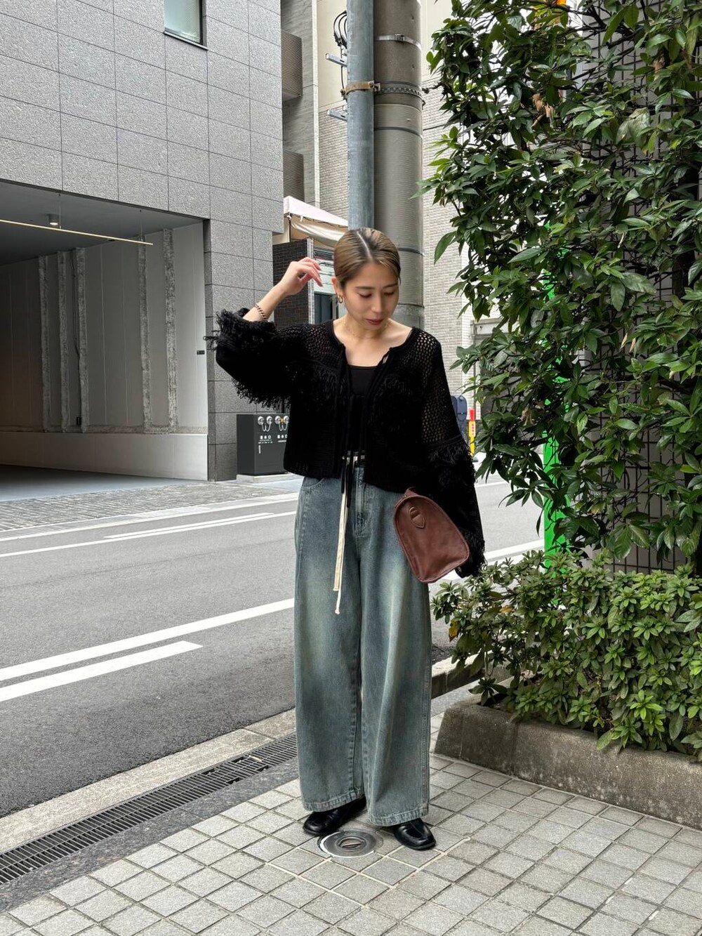 ブラウン系のボストンバッグ、ブルー系のデニムパンツ、ブラック系のニット/セーターを着用したレディースの冬コーディネートの6枚目の写真