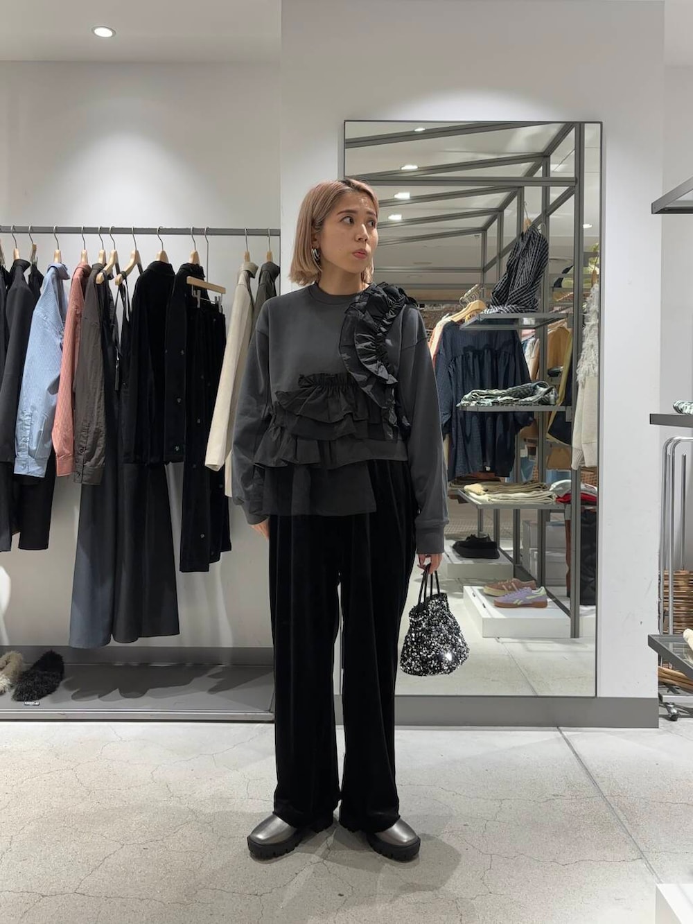 シルバー系のショルダーバッグ、シルバー系のブーツ、ブラック系のその他パンツを着用したレディースの秋コーディネートの2枚目の写真