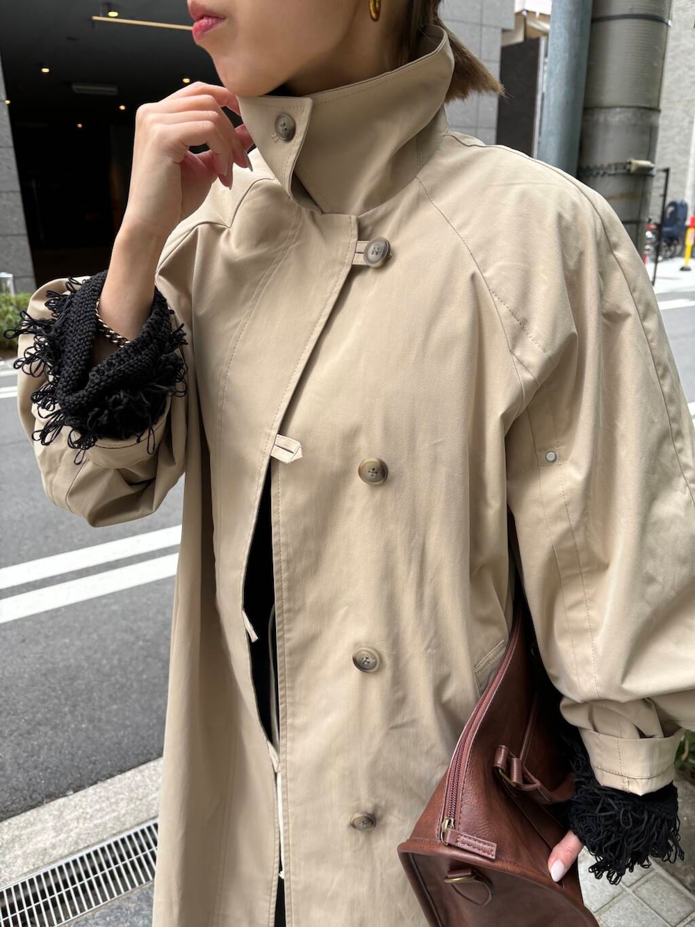 ブラウン系のボストンバッグ、ブルー系のデニムパンツ、ブラック系のニット/セーターを着用したレディースの冬コーディネートの3枚目の写真