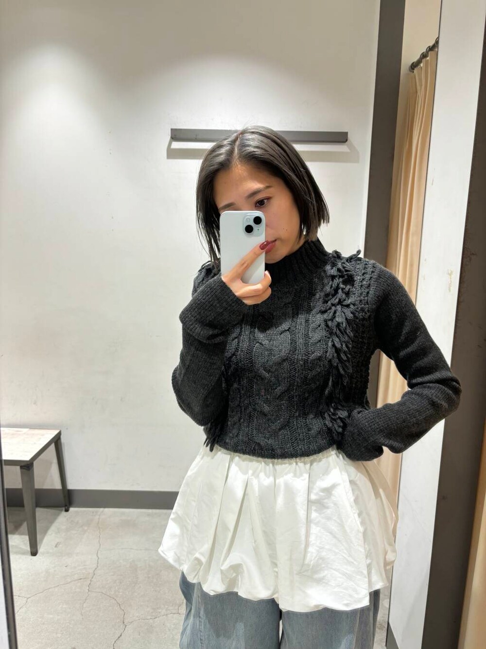 ブルー系のデニムパンツ、ホワイト系のカーディガン/ボレロ、グレー系のニット/セーターを着用したレディースの冬コーディネートの4枚目の写真