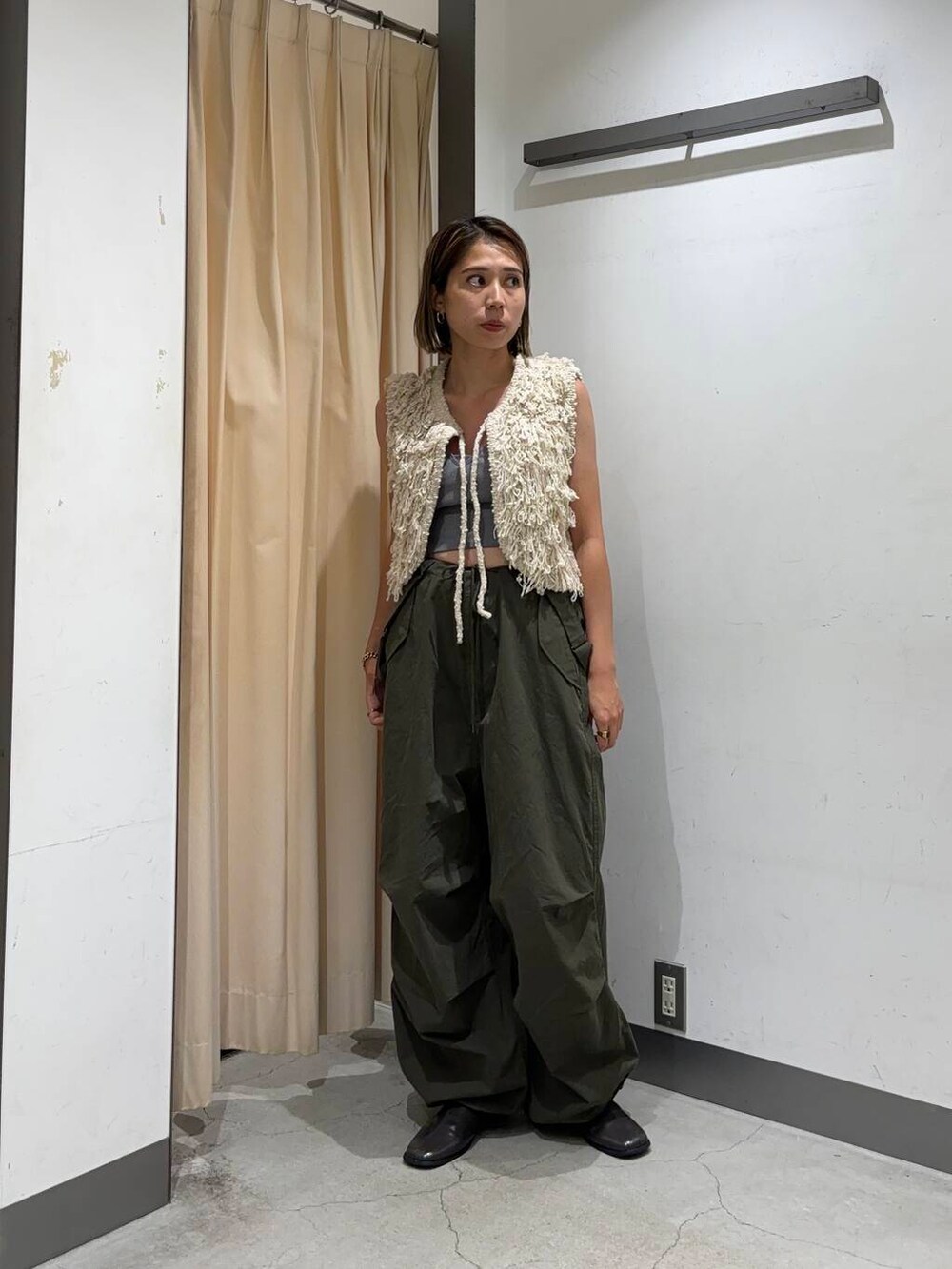 ベージュ系のベスト、グリーン系のその他パンツを着用したレディースの夏コーディネートの2枚目の写真