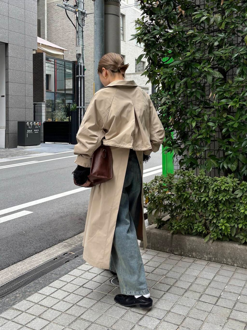 ブラウン系のボストンバッグ、ブルー系のデニムパンツ、ブラック系のニット/セーターを着用したレディースの冬コーディネートの2枚目の写真