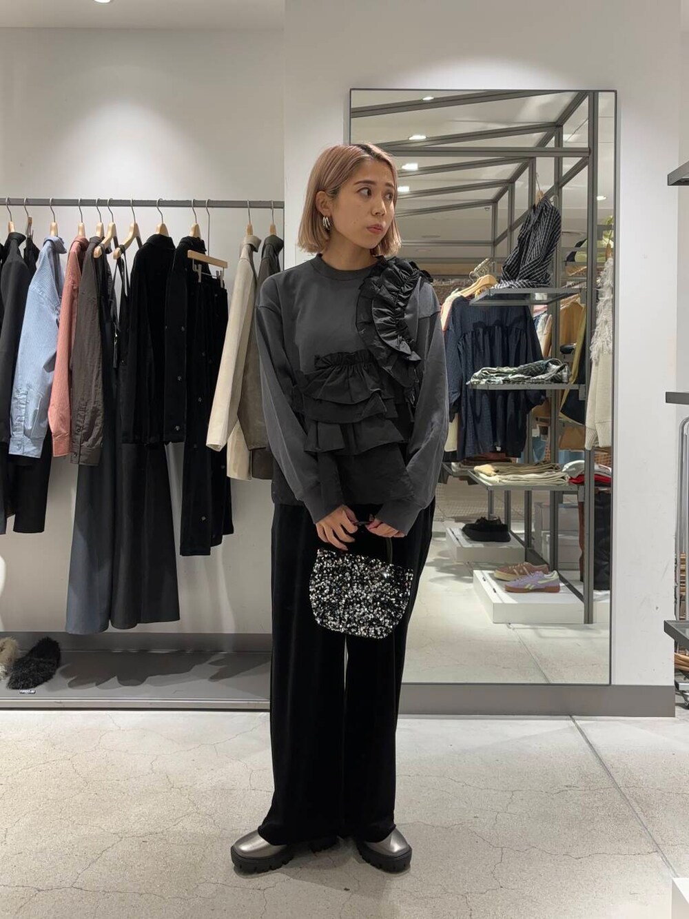 シルバー系のショルダーバッグ、シルバー系のブーツ、ブラック系のその他パンツを着用したレディースの秋コーディネートの3枚目の写真