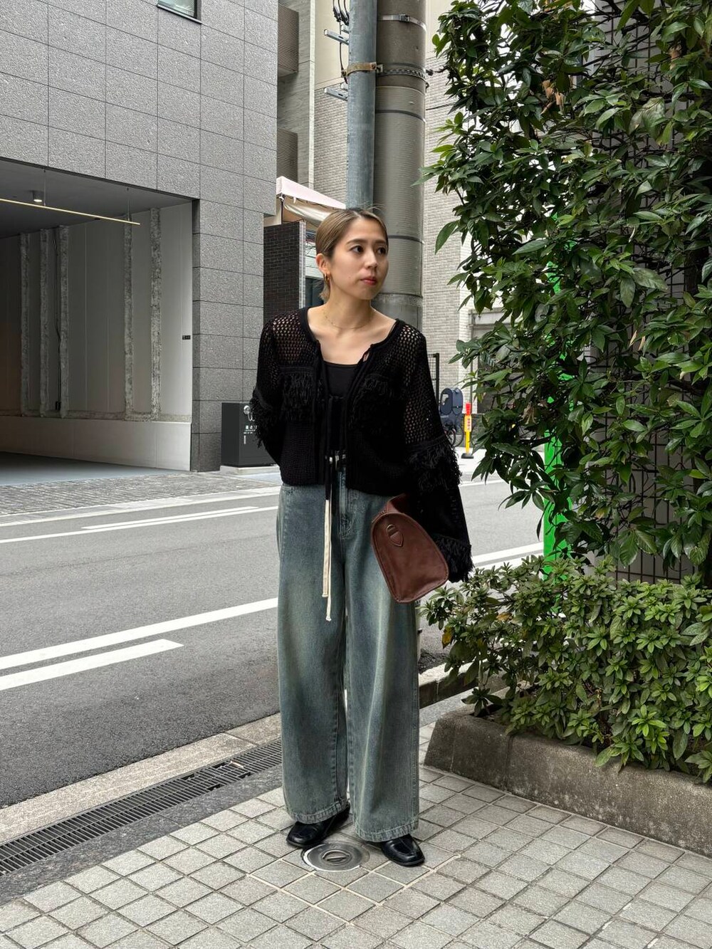 ブラウン系のボストンバッグ、ブルー系のデニムパンツ、ブラック系のニット/セーターを着用したレディースの冬コーディネートの7枚目の写真