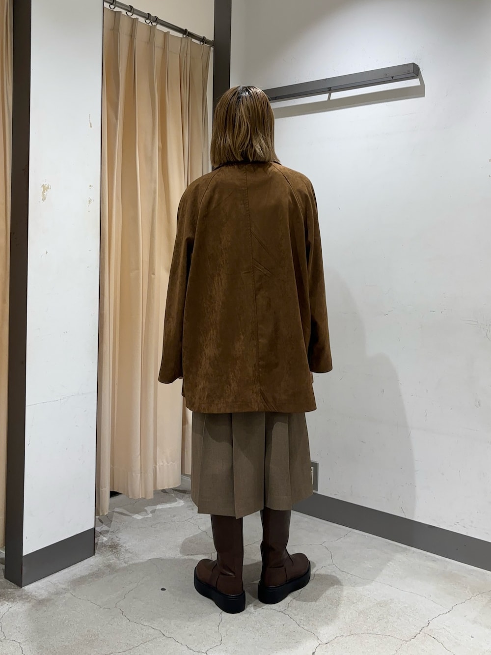 ブラウン系のカバーオール、ブラウン系のベスト、ブラウン系のスカートを着用したレディースの秋コーディネートの2枚目の写真