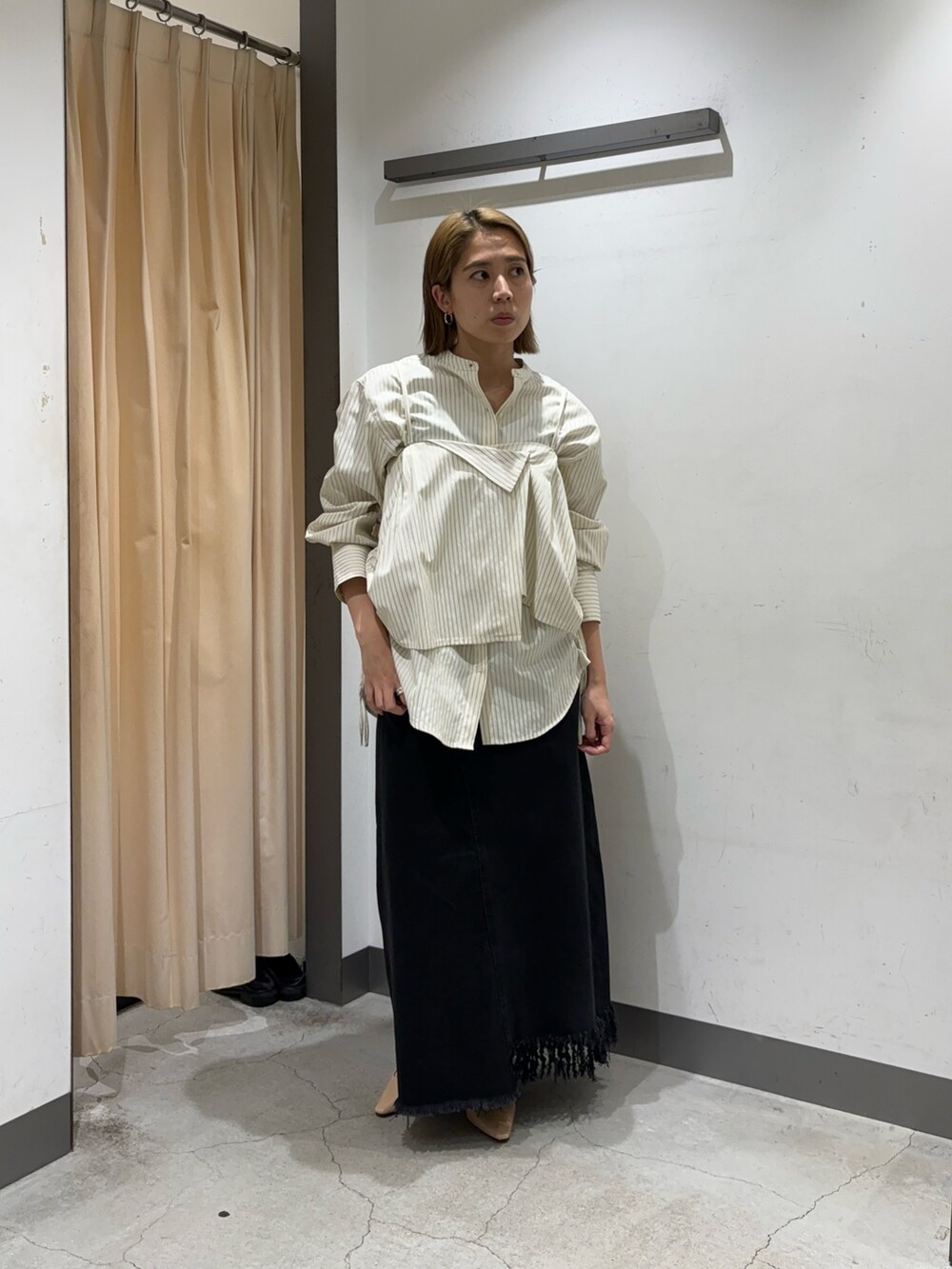 ブラック系のスカート、ホワイト系のシャツ/ブラウスを着用したレディースの春コーディネートの2枚目の写真