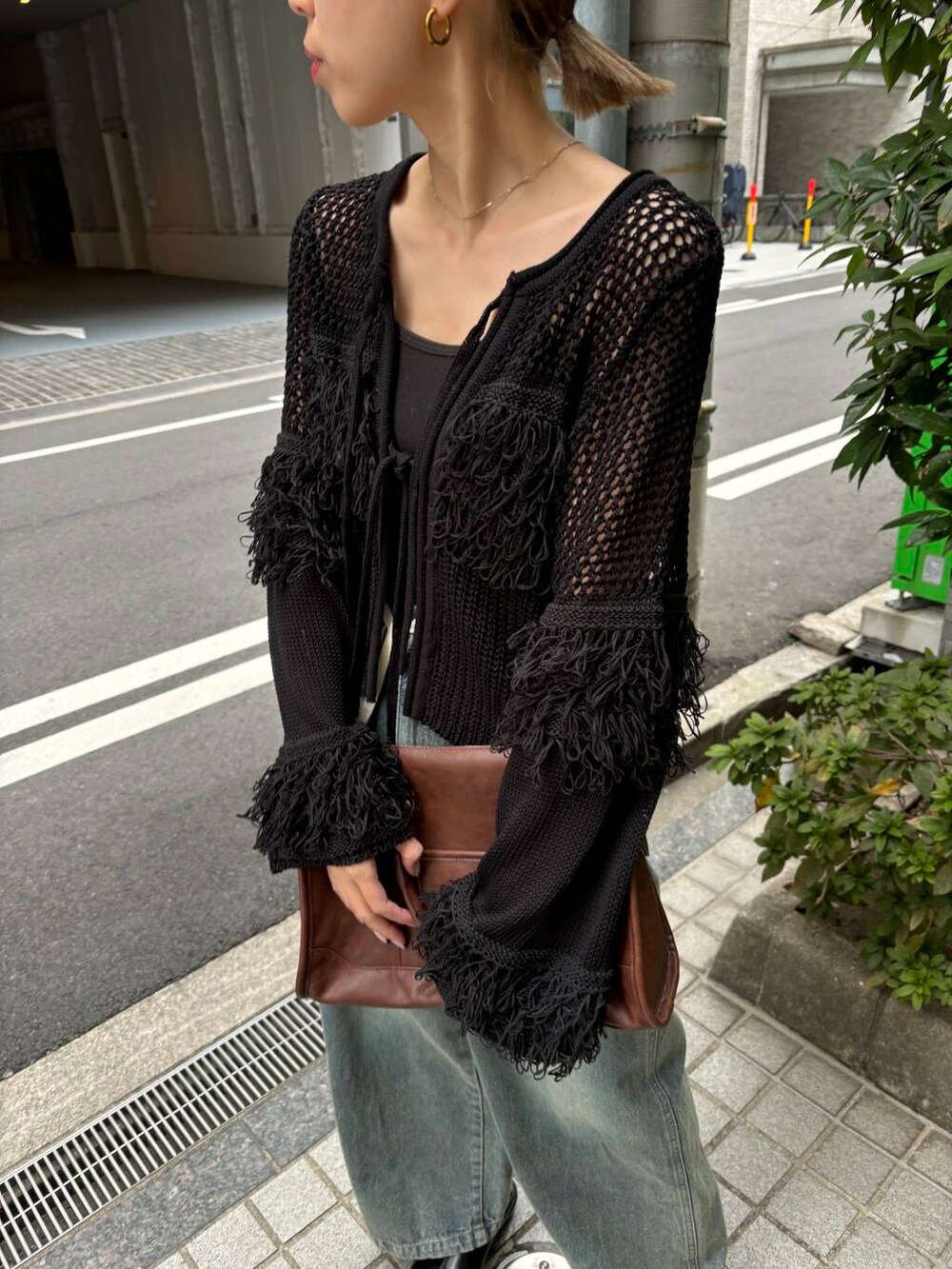 ブラウン系のボストンバッグ、ブルー系のデニムパンツ、ブラック系のニット/セーターを着用したレディースの冬コーディネートの5枚目の写真