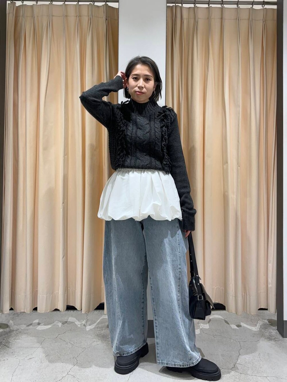 ブルー系のデニムパンツ、ホワイト系のカーディガン/ボレロ、グレー系のニット/セーターを着用したレディースの冬コーディネートの2枚目の写真