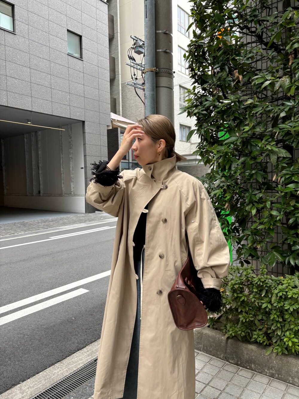 ブラウン系のボストンバッグ、ブルー系のデニムパンツ、ブラック系のニット/セーターを着用したレディースの冬コーディネートの4枚目の写真