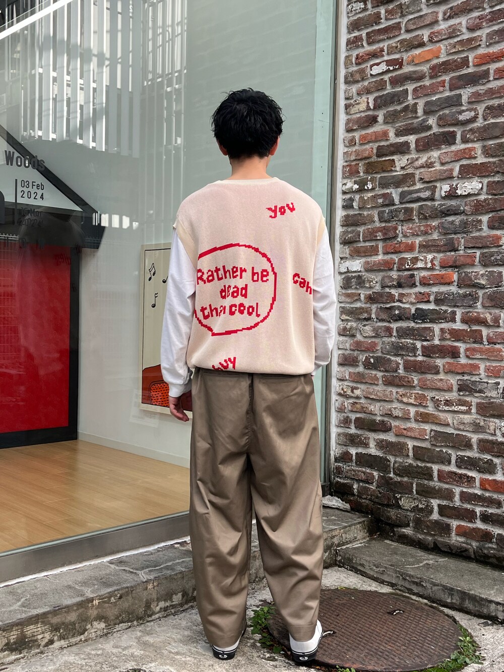 ベージュ系のベスト、ベージュ系のチノパンツを着用したメンズの春コーディネートの2枚目の写真