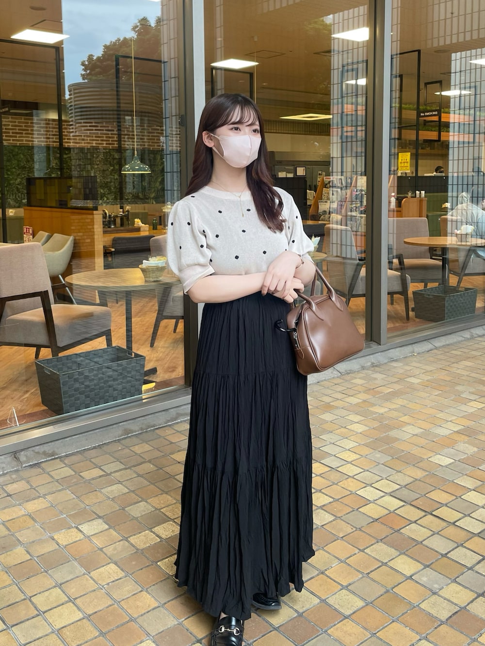 ベージュ系のニット/セーター、ブラック系のスカート、ブラック系のローファーを着用したレディースの夏コーディネートの3枚目の写真