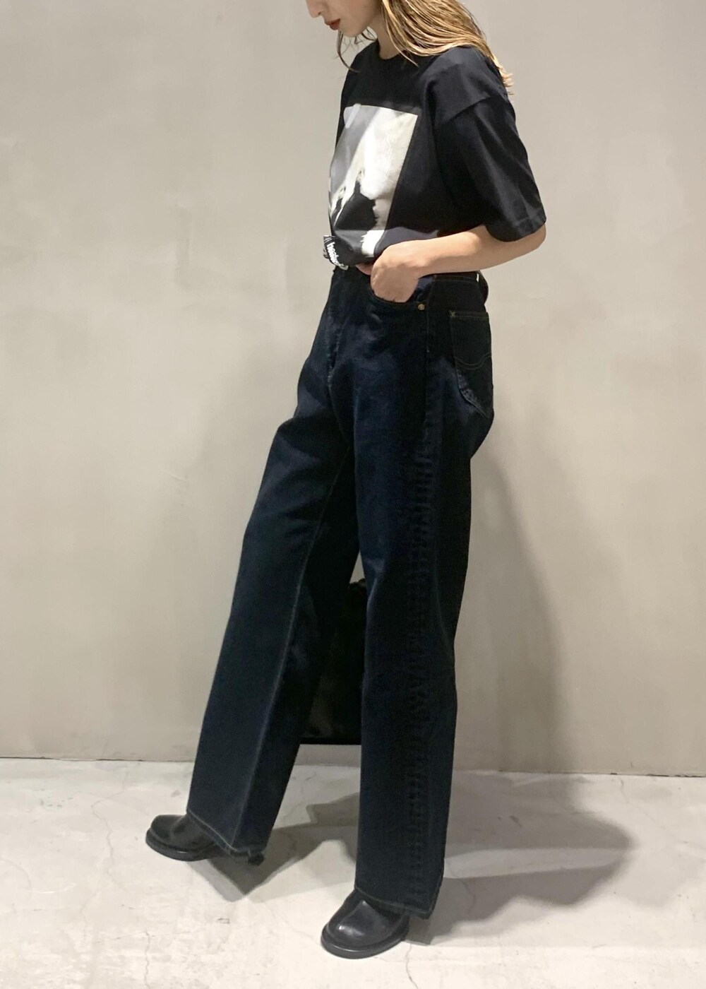 ブラック系のサンダル、ブラック系のショルダーバッグ、ブラック系のデニムパンツを着用したレディースの秋コーディネートの2枚目の写真