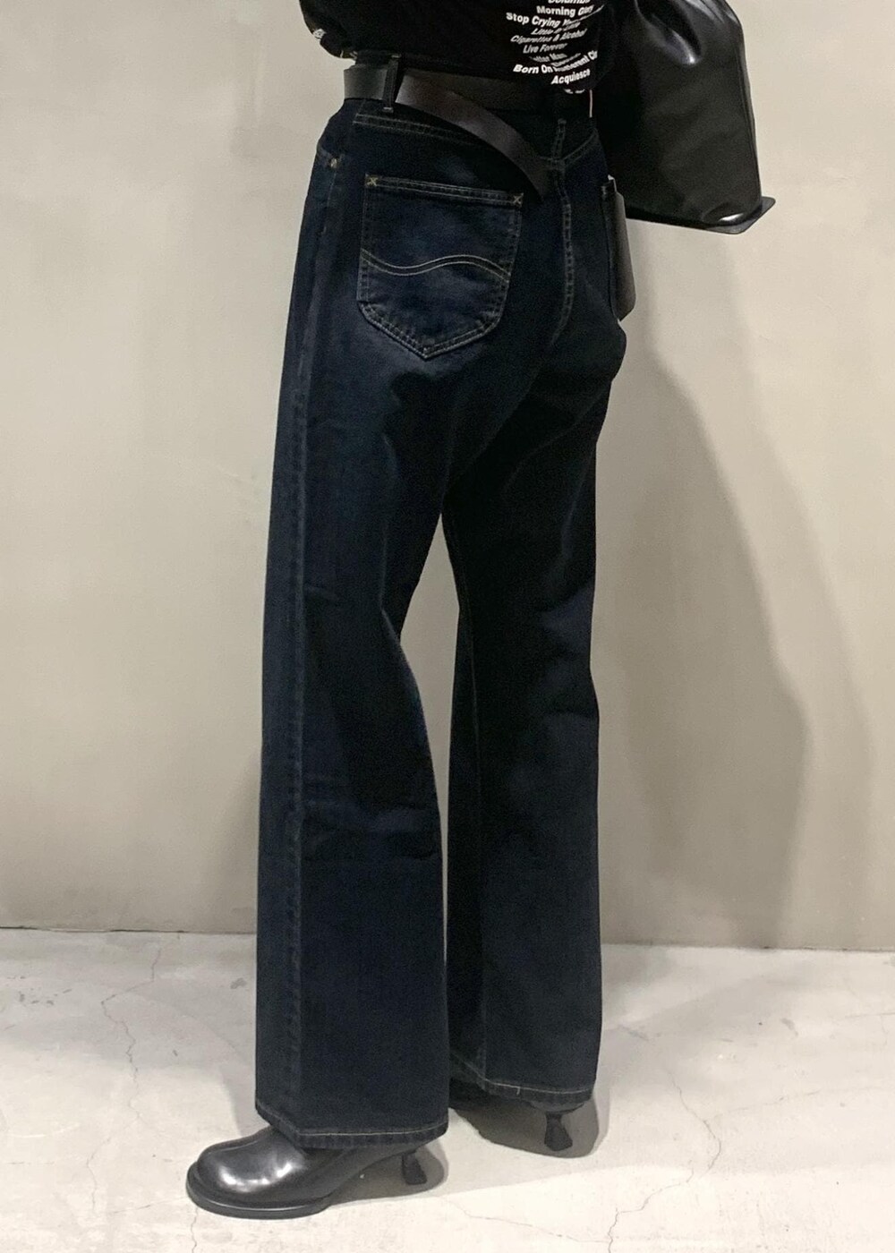 ブラック系のサンダル、ブラック系のショルダーバッグ、ブラック系のデニムパンツを着用したレディースの秋コーディネートの3枚目の写真