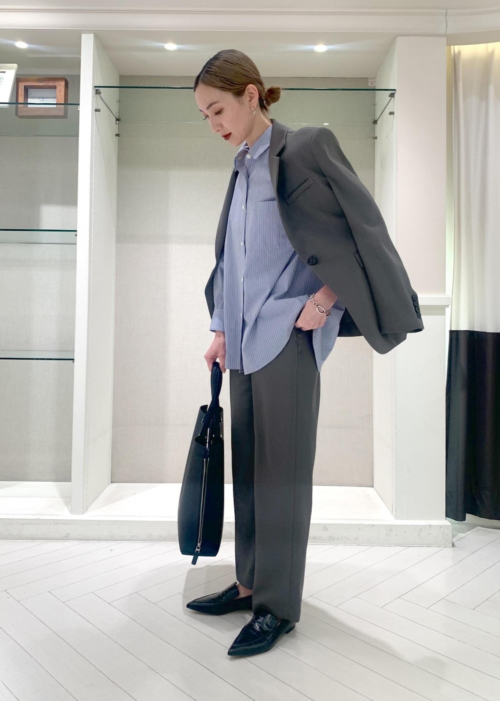 ブラック系のパンプス、ブルー系のシャツ/ブラウス、グレー系のその他パンツを着用したレディースの春コーディネートの2枚目の写真