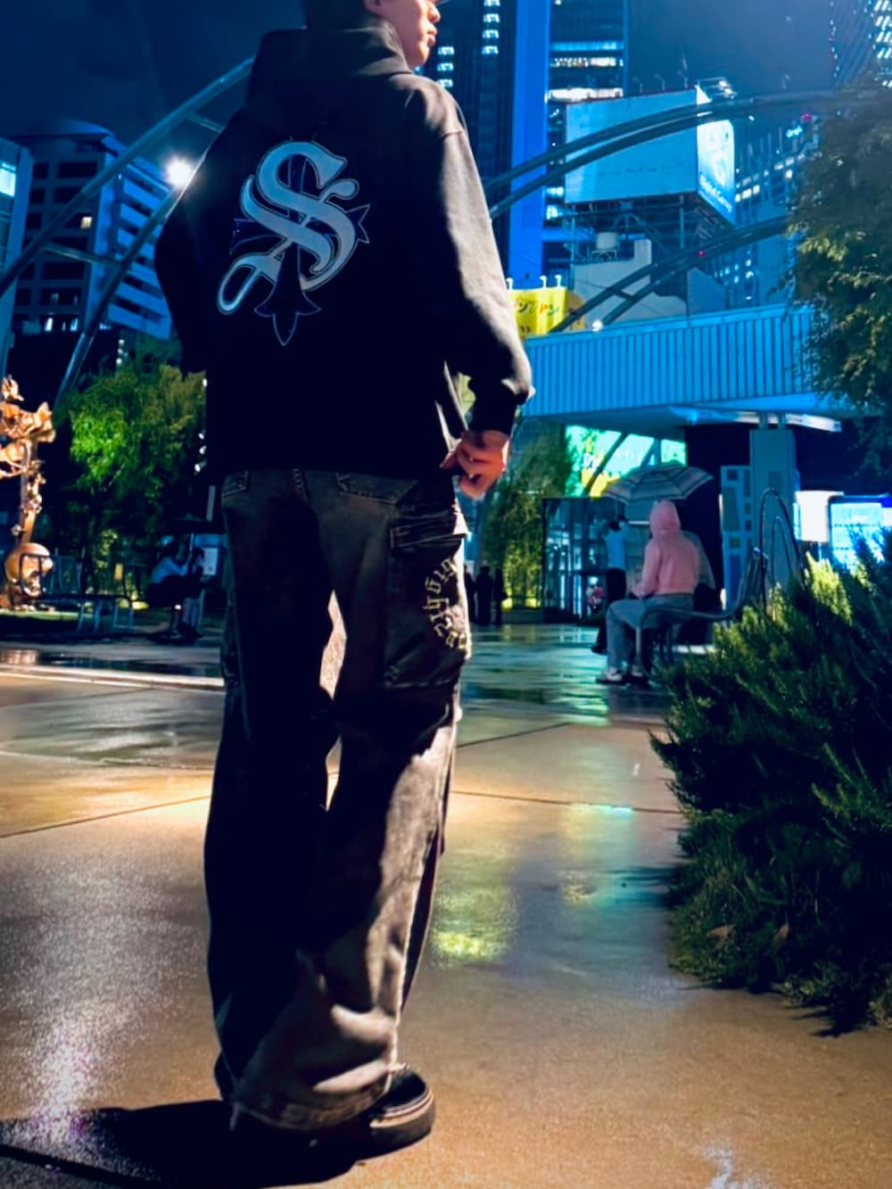 ブラック系のパーカー、ブラック系のブーツ、ブラック系のカーゴパンツを着用したメンズの春コーディネートの2枚目の写真