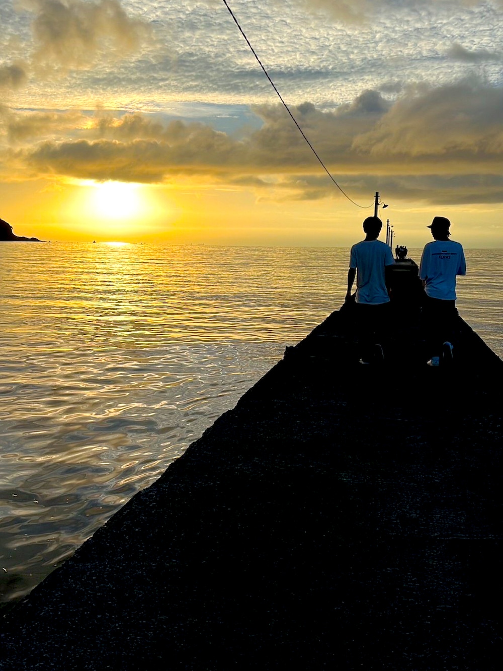 ブルー系のカーゴパンツ、ホワイト系のスニーカー、ブラック系のハットを着用したメンズの春コーディネートの3枚目の写真