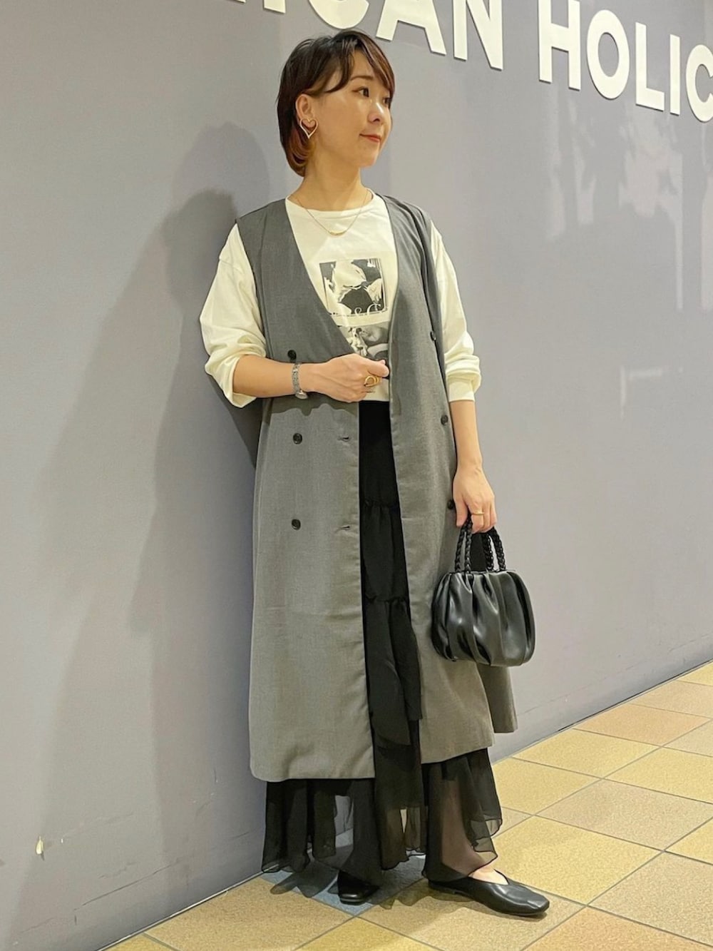 「ジレスタイル、ジレ、ジレコーデ、ロングジレ、ベストコーデ、プリントT、フォトプリント、長袖カットソー、ティアードスカート、ティアードスカートコーデ、フリルスカート、パンプスコーデ、パンプス 黒、アメリカンホリック、AMERICAN HOLIC」|「AMERICAN HOLICの編み込みハンドルミニショルダーBAG(ショルダーバッグ、ブラック系)」を使った、ah.susuyuさん(骨格ストレート・レディース・158cm)の秋コーディネートの2枚目の写真