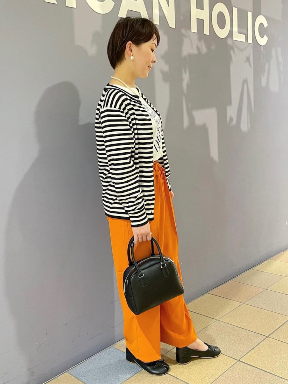 「ボーダーカーディガン、モックネックニット、接触冷感パンツ、ハデ色、オレンジパンツ、大人カジュアルコーデ、ロゴTシャツ、足袋パンプス、タビシューズ、アメホリ、アメリカンホリック、プチプラコーデ、ボーダーコーデ、カーディガンコーデ、ボーダー×パール」|「AMERICAN HOLICの2wayボストンミニバッグ(ボストンバッグ、ブラック系)」を使った、ah.susuyuさん(骨格ストレート・レディース・158cm)の春コーディネートの3枚目の写真
