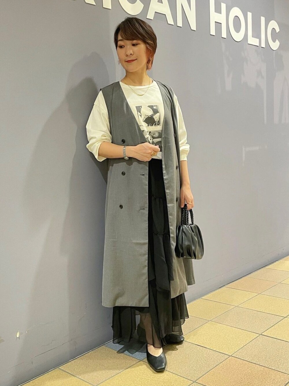 「ジレスタイル、ジレ、ジレコーデ、ロングジレ、ベストコーデ、プリントT、フォトプリント、長袖カットソー、ティアードスカート、ティアードスカートコーデ、フリルスカート、パンプスコーデ、パンプス 黒、アメリカンホリック、AMERICAN HOLIC」|「AMERICAN HOLICの編み込みハンドルミニショルダーBAG(ショルダーバッグ、ブラック系)」を使った、ah.susuyuさん(骨格ストレート・レディース・158cm)の秋コーディネートの5枚目の写真
