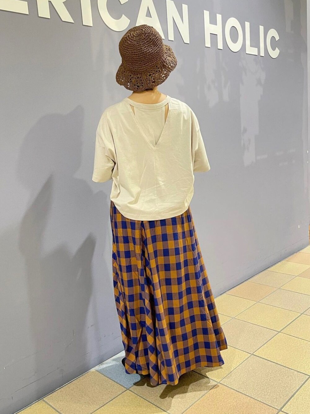 グレー系のTシャツ/カットソー、ブラウン系のショルダーバッグ、ブルー系のスカートを着用したレディースの夏コーディネートの5枚目の写真