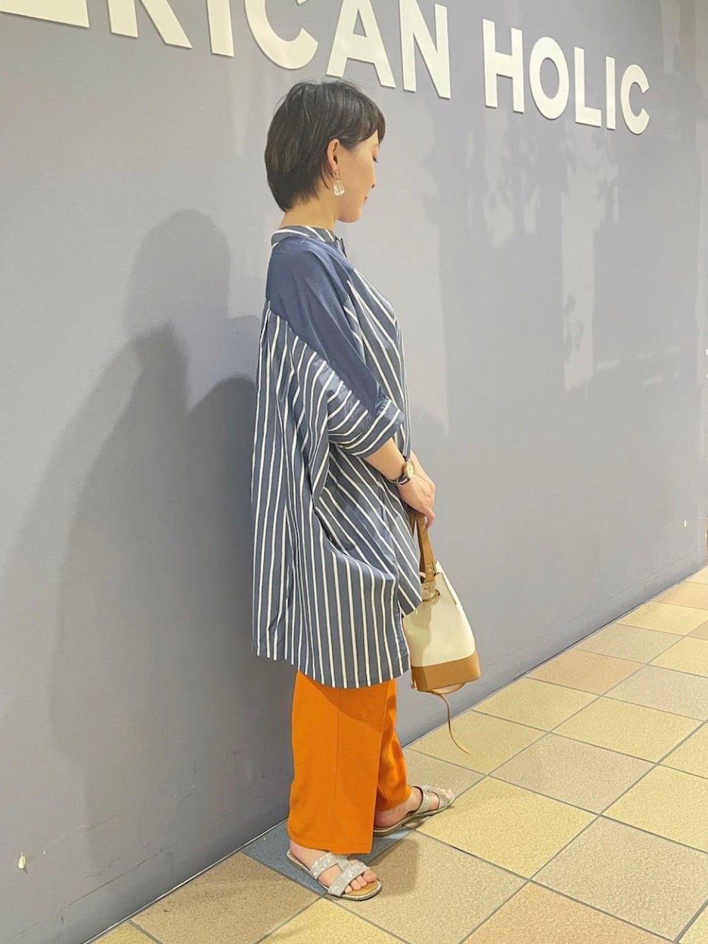 「ポンチョシャツ、シャツチュニック、ストライプシャツチュニック、ストライプシャツ、カラーパンツコーデ、カラーパンツ、センタープレスパンツ、接触冷感パンツ、カラーパンツ　オレンジ、オフィスカジュアル、アメリカンホリック、AMERICAN HOLIC、ハンサムコーデ、ワイドパンツコーデ」｜「AMERICAN HOLICの2Wayロゴキャンバスショルダーバッグ（ショルダーバッグ、ベージュ系）」を使った、ah.susuyuさん（骨格ストレート・レディース・158cm）の春コーディネートの2枚目の写真