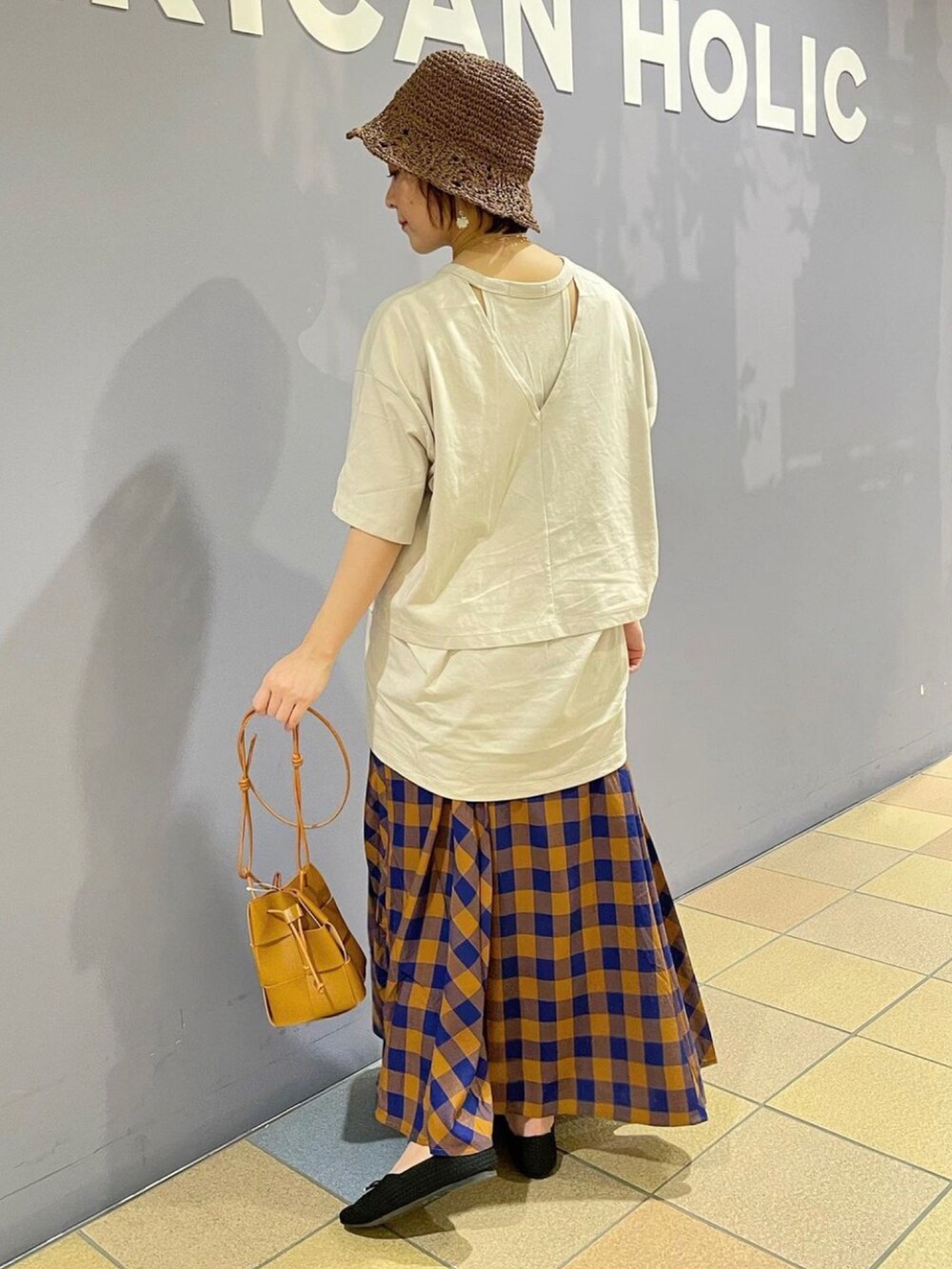 グレー系のTシャツ/カットソー、ブラウン系のショルダーバッグ、ブルー系のスカートを着用したレディースの夏コーディネートの3枚目の写真