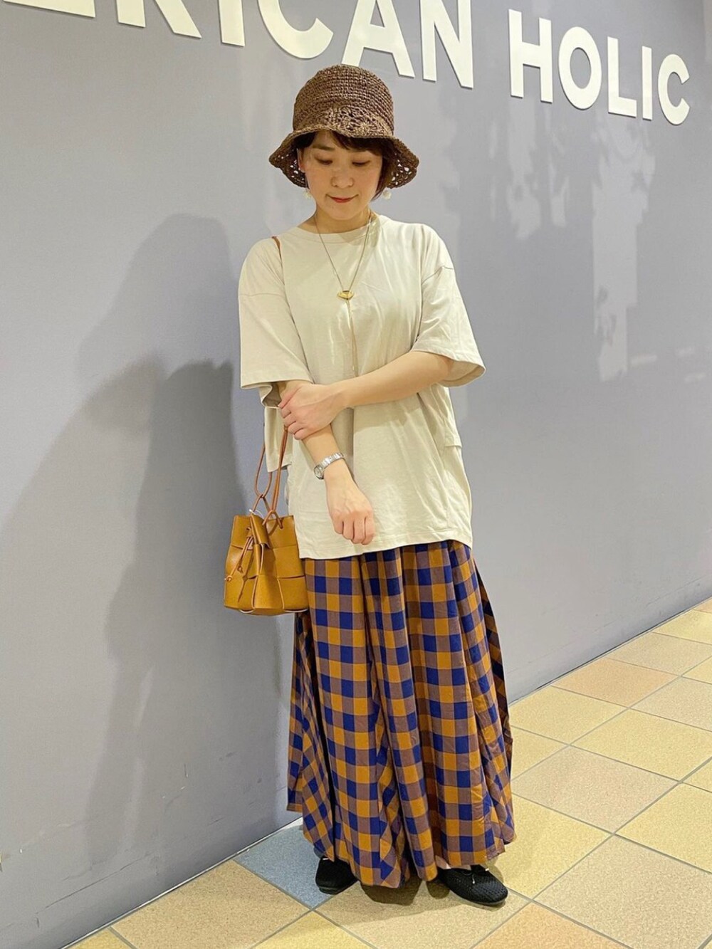 グレー系のTシャツ/カットソー、ブラウン系のショルダーバッグ、ブルー系のスカートを着用したレディースの夏コーディネートの4枚目の写真