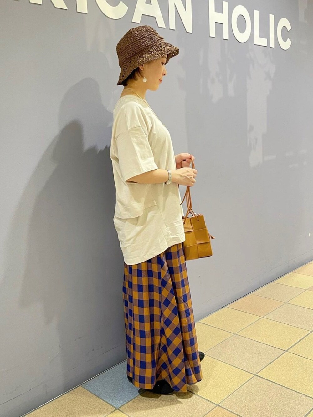 グレー系のTシャツ/カットソー、ブラウン系のショルダーバッグ、ブルー系のスカートを着用したレディースの夏コーディネートの2枚目の写真