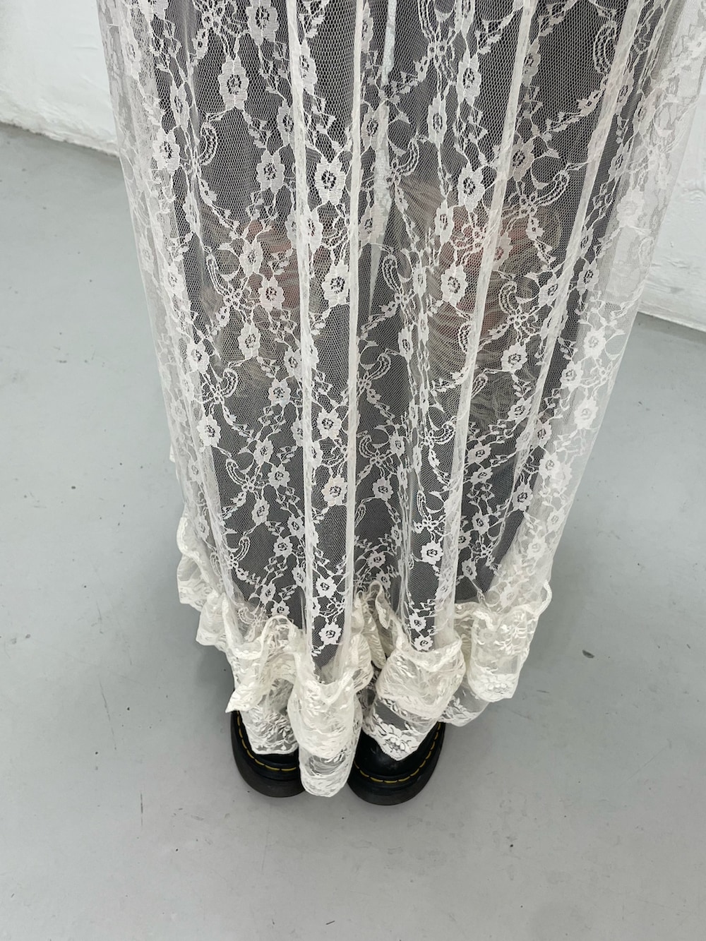 ブルー系のニット/セーター、ホワイト系のワンピース、ブラック系のデニムパンツを着用したレディースの春コーディネートの9枚目の写真