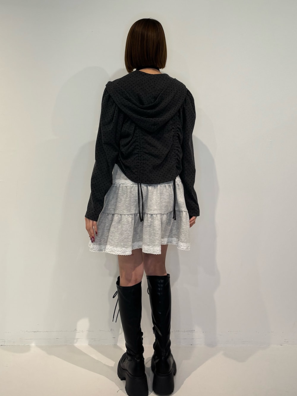 ブラック系のパーカー、グレー系のワンピース、ブラック系のブーツを着用したレディースの冬コーディネートの4枚目の写真