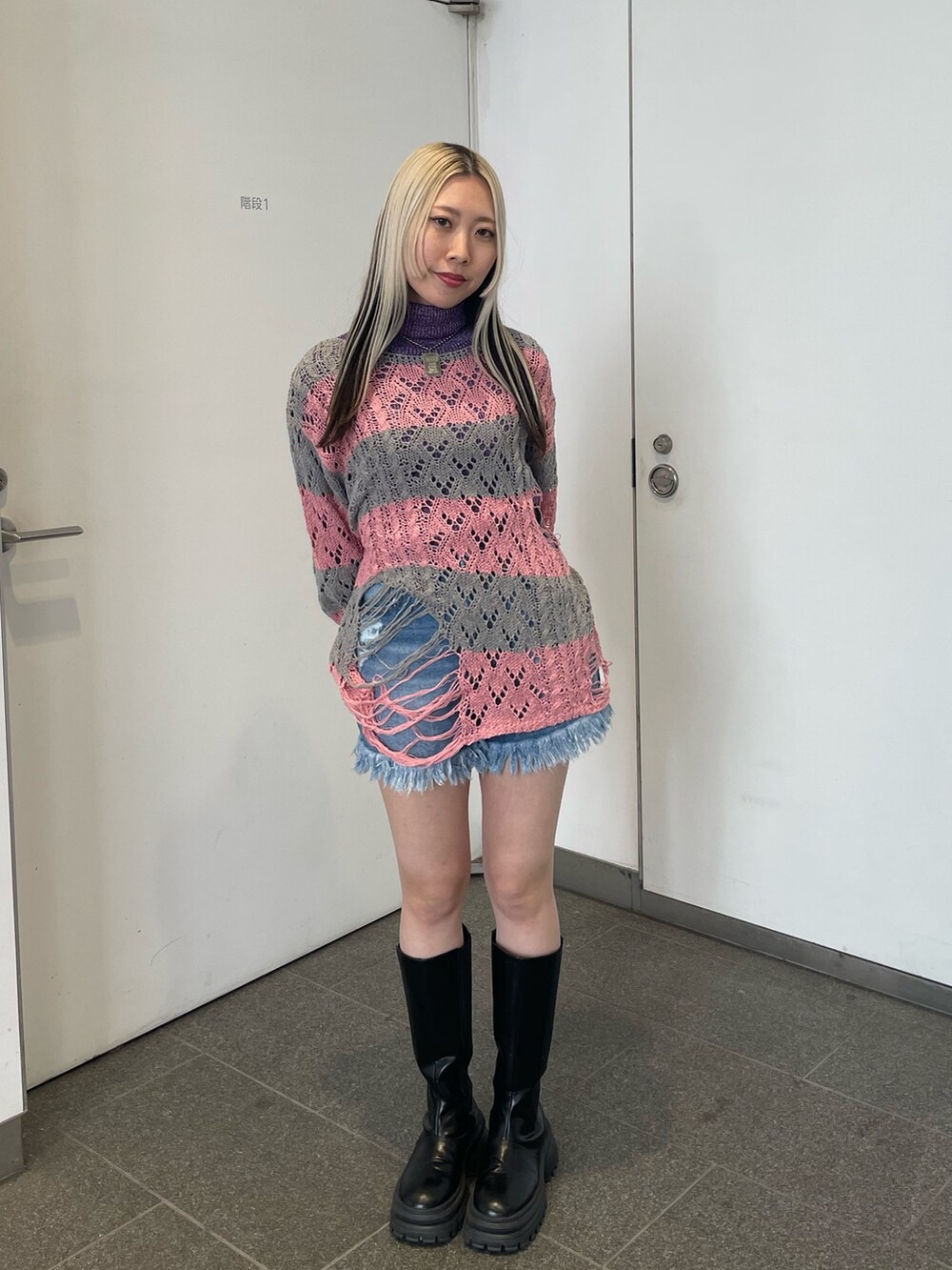 ピンク系のニット/セーター、パープル系のニット/セーター、ブルー系のデニムパンツを着用したレディースの冬コーディネートの3枚目の写真