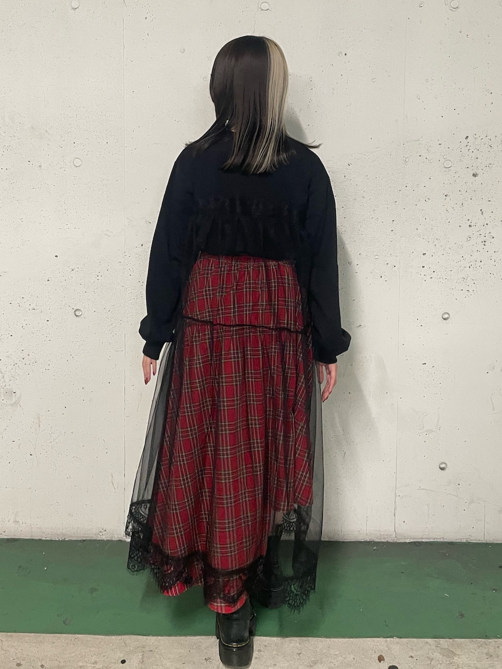 レッド系のスカート、ブラック系のワンピース、レッド系のネックレスを着用したレディースの冬コーディネートの3枚目の写真