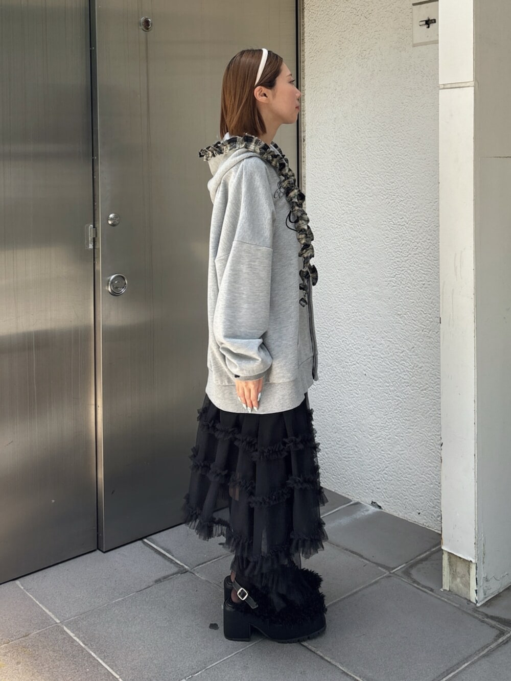 グレー系のその他トップス、ブラック系のスカート、ブラック系のサンダルを着用したレディースの夏コーディネートの3枚目の写真