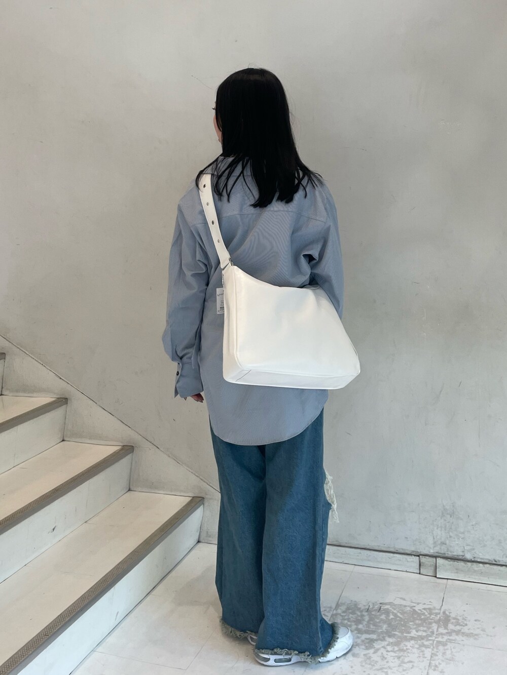 ブルー系のシャツ/ブラウス、シルバー系のショルダーバッグ、ブルー系のデニムパンツを着用したレディースの春コーディネートの4枚目の写真