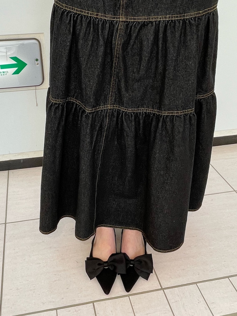 ブラック系のワンピース、ホワイト系のTシャツ/カットソー、ブラック系のパンプスを着用したレディースの春コーディネートの10枚目の写真