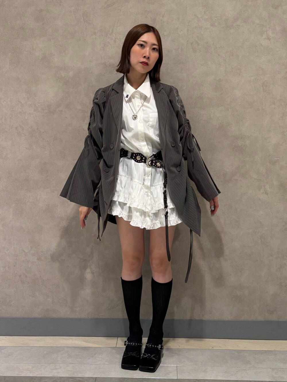 ホワイト系のワンピース、ブラック系のパンプス、グレー系のテーラードジャケットを着用したレディースの夏コーディネートの2枚目の写真