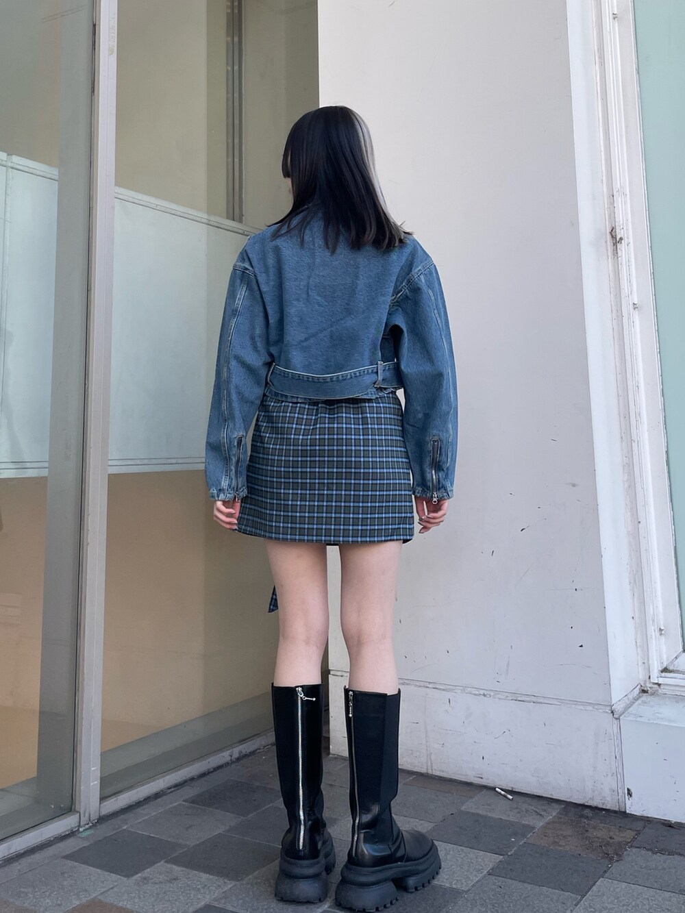 グリーン系のスカート、ブルー系のライダースジャケット、ブルー系のニット/セーターを着用したレディースの冬コーディネートの3枚目の写真