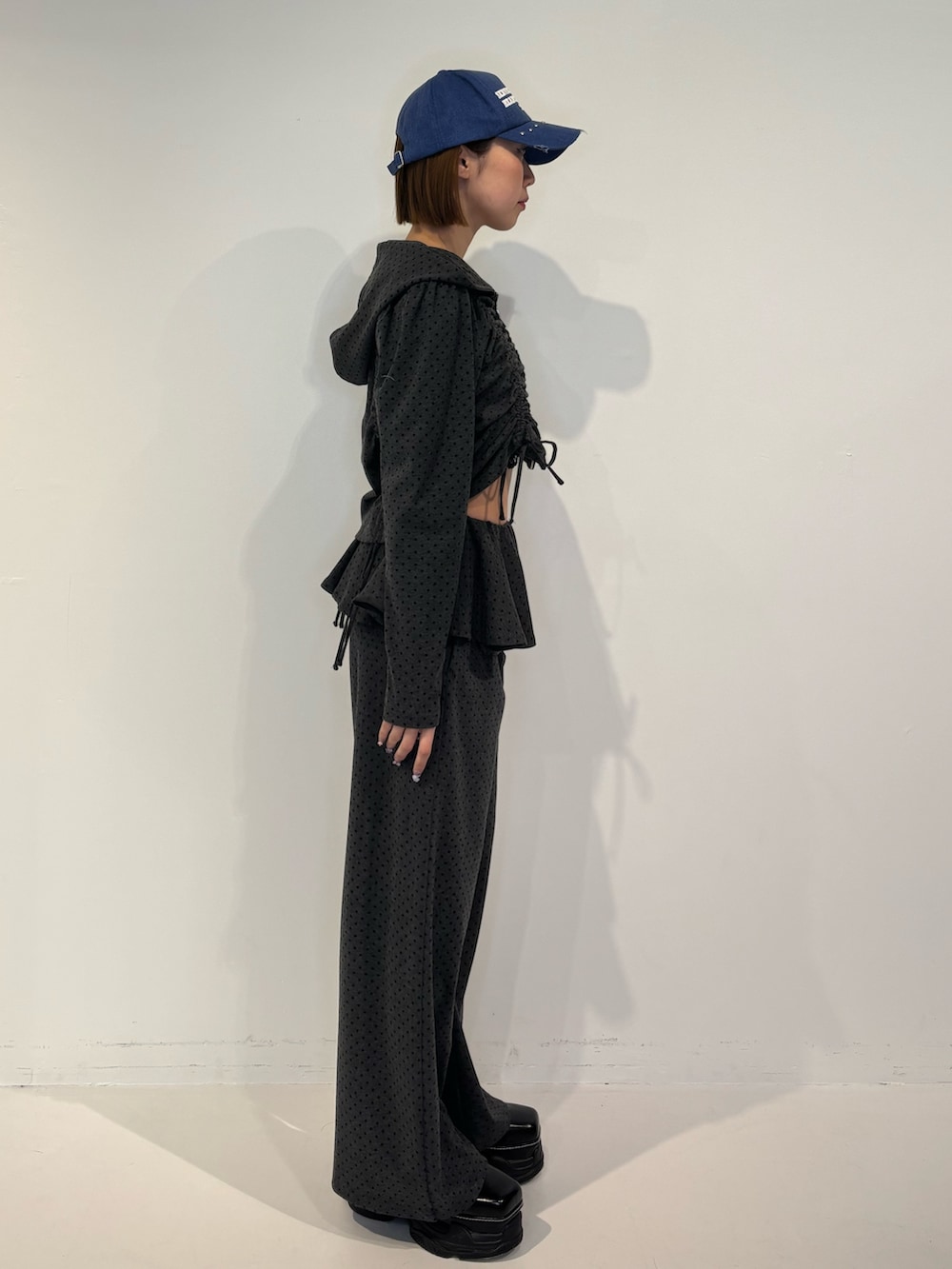 グレー系のスウェットパンツ、ブラック系のパーカー、ブラック系のローファーを着用したレディースの冬コーディネートの3枚目の写真