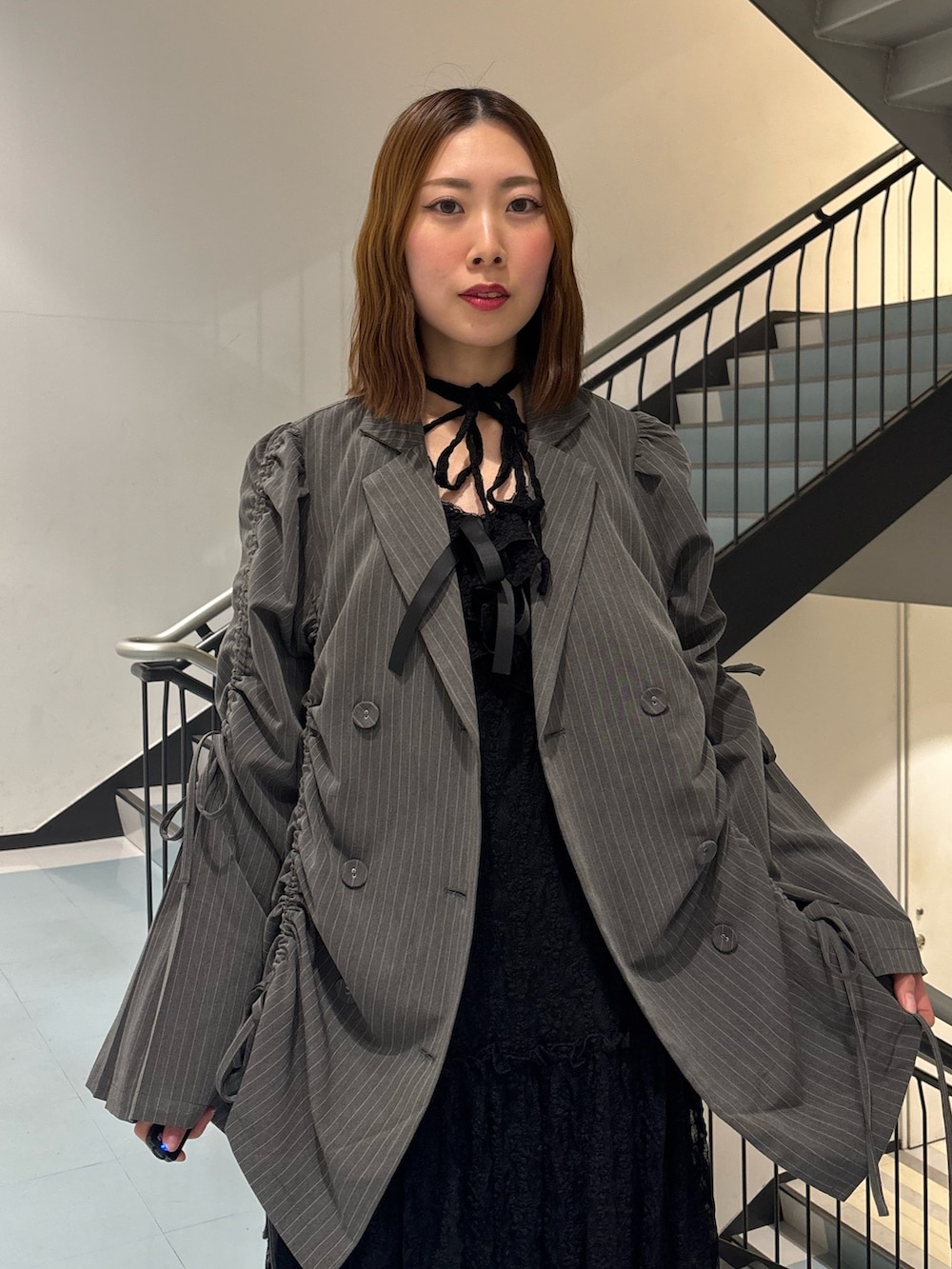 ブラック系のワンピース、グレー系のテーラードジャケット、ブラウン系のブーツを着用したレディースの冬コーディネートの6枚目の写真